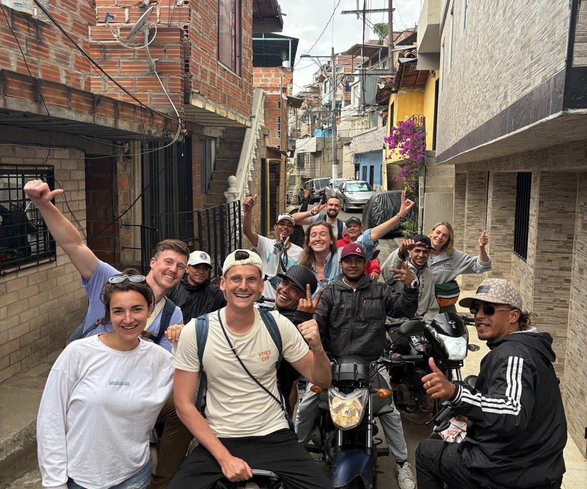 Voyageurs échangeant avec les habitants de la Comuna 3 à Medellín lors d'une expérience immersive.