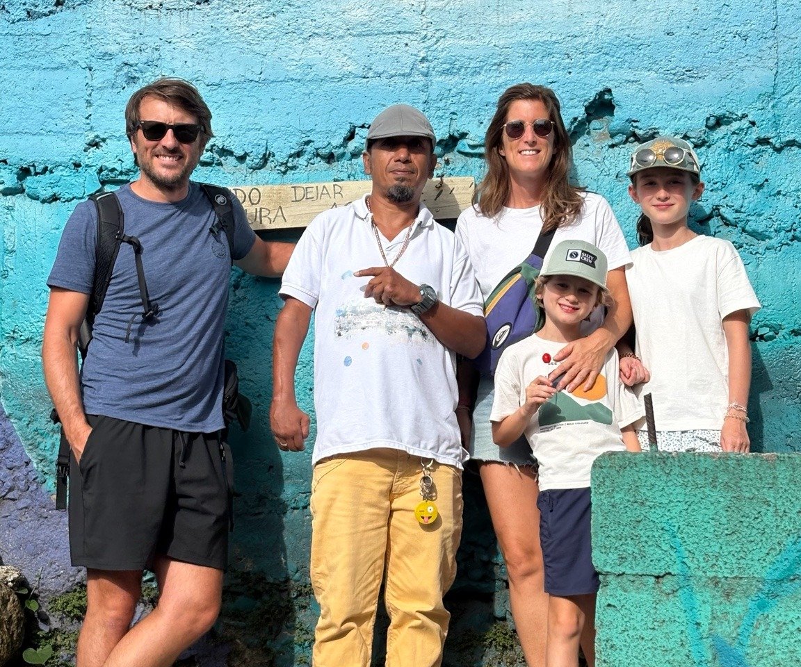 Famille accompagnée d'un leader social dans la Comuna 3 à Medellín pendant une visite authentique.