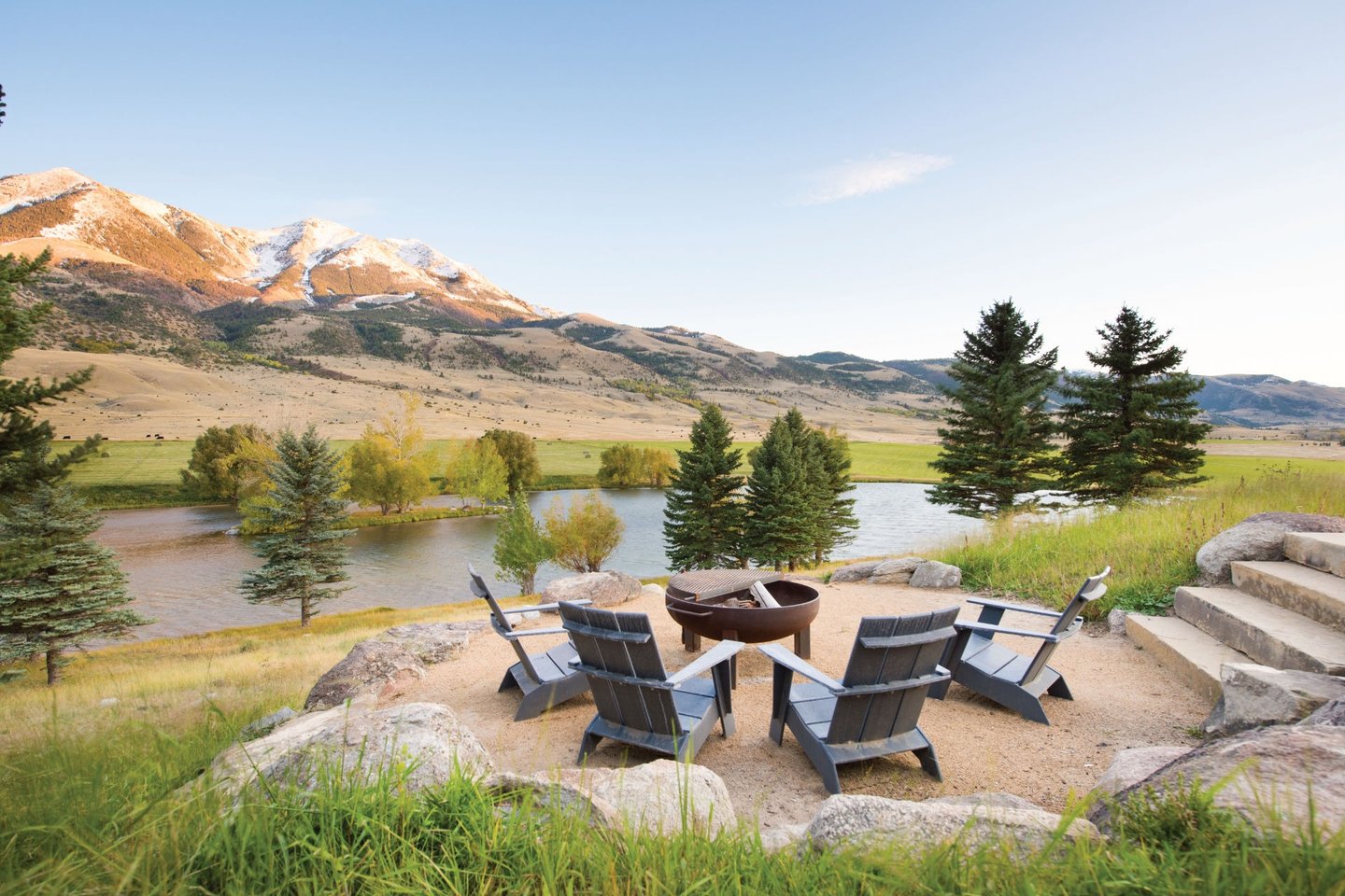 fire pit and chairs overlooking a lake