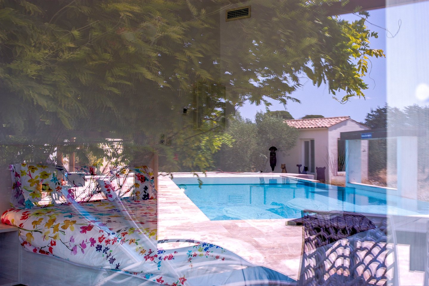 Bedroom with king size bed, swimming pool view being seen from outside at Domaine Des Lucques