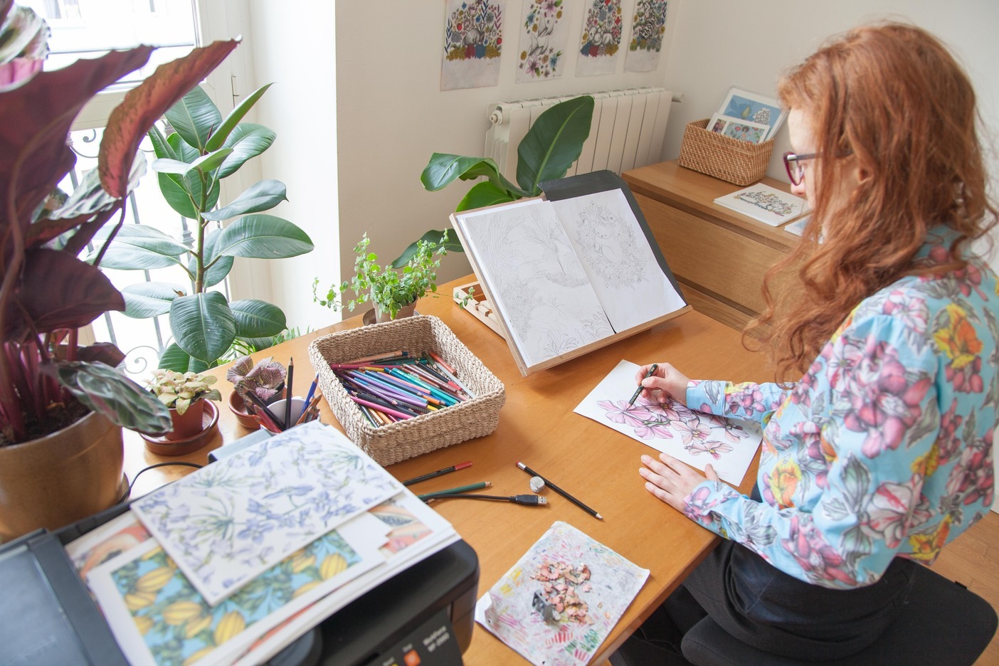 a woman sitting at a desk drawing