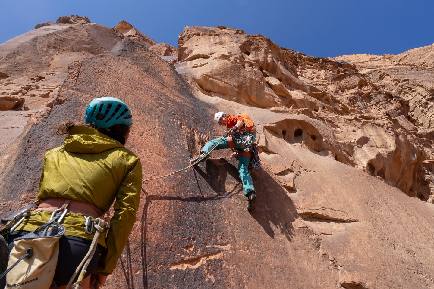 Female climbers lead up an imposing desert headwall in Wadi Rum, Jordan
