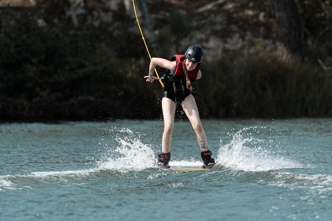 Une femme en train d'effectuer une figure en wakeboard