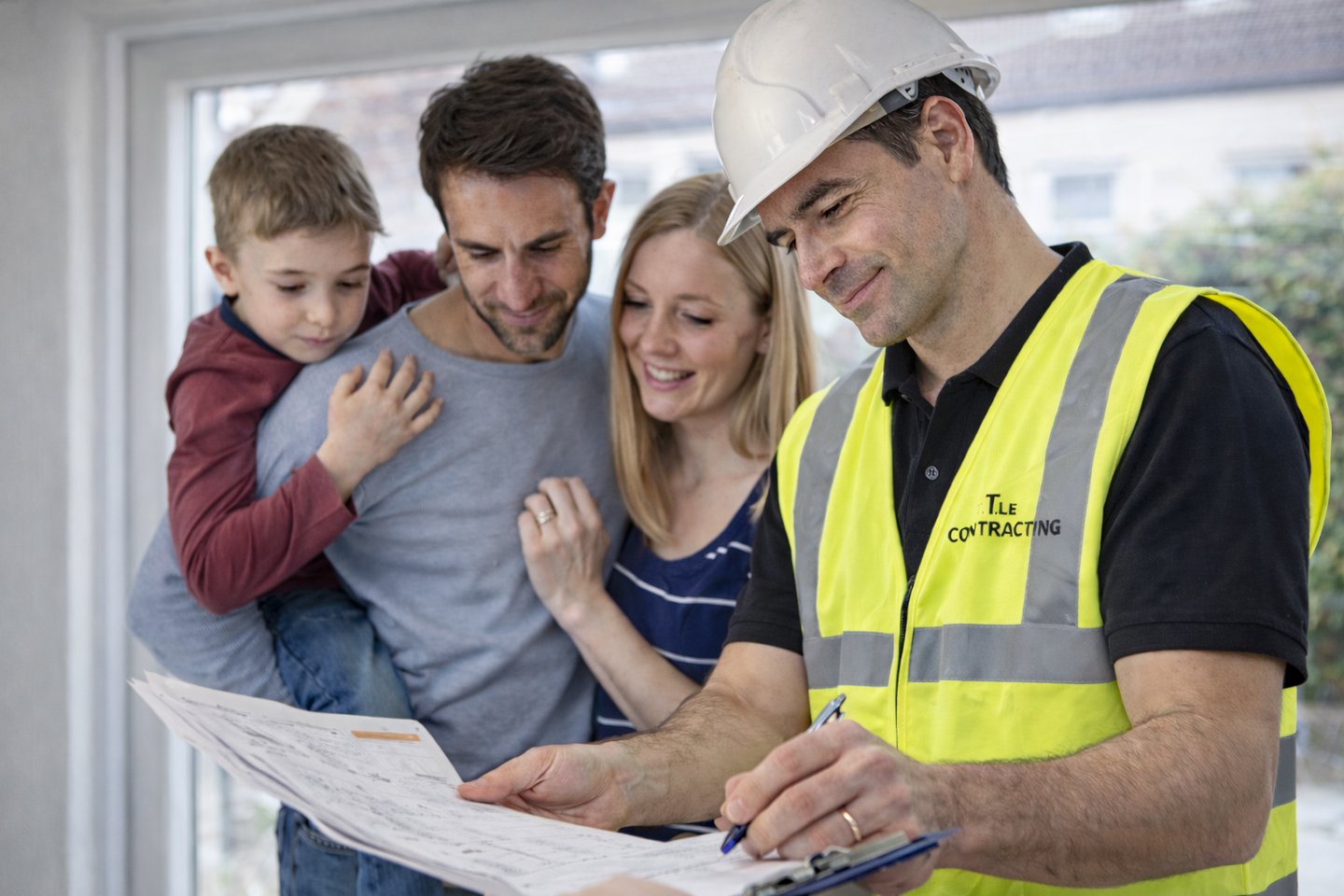 T.LE Contracting builder showing blueprints to a family during a Brighton home renovation.