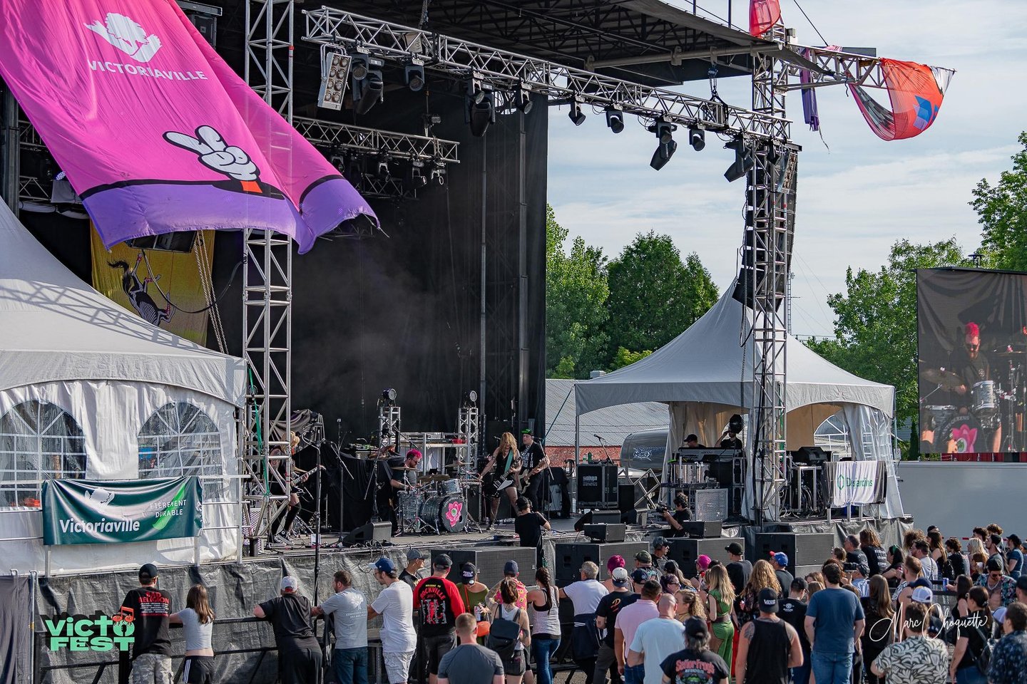 Live rock band performing on a large outdoor concert stage at VictoFest in Victoriaville.