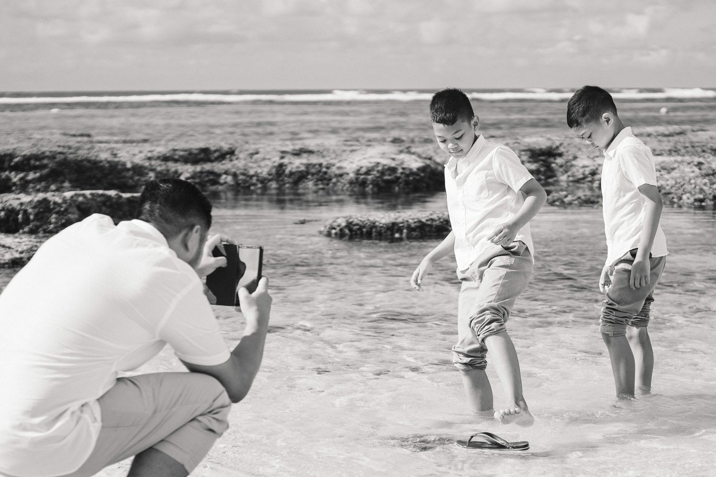 Ayunda family sharing a candid moment by the shoreline at Melasti Beach Bali.