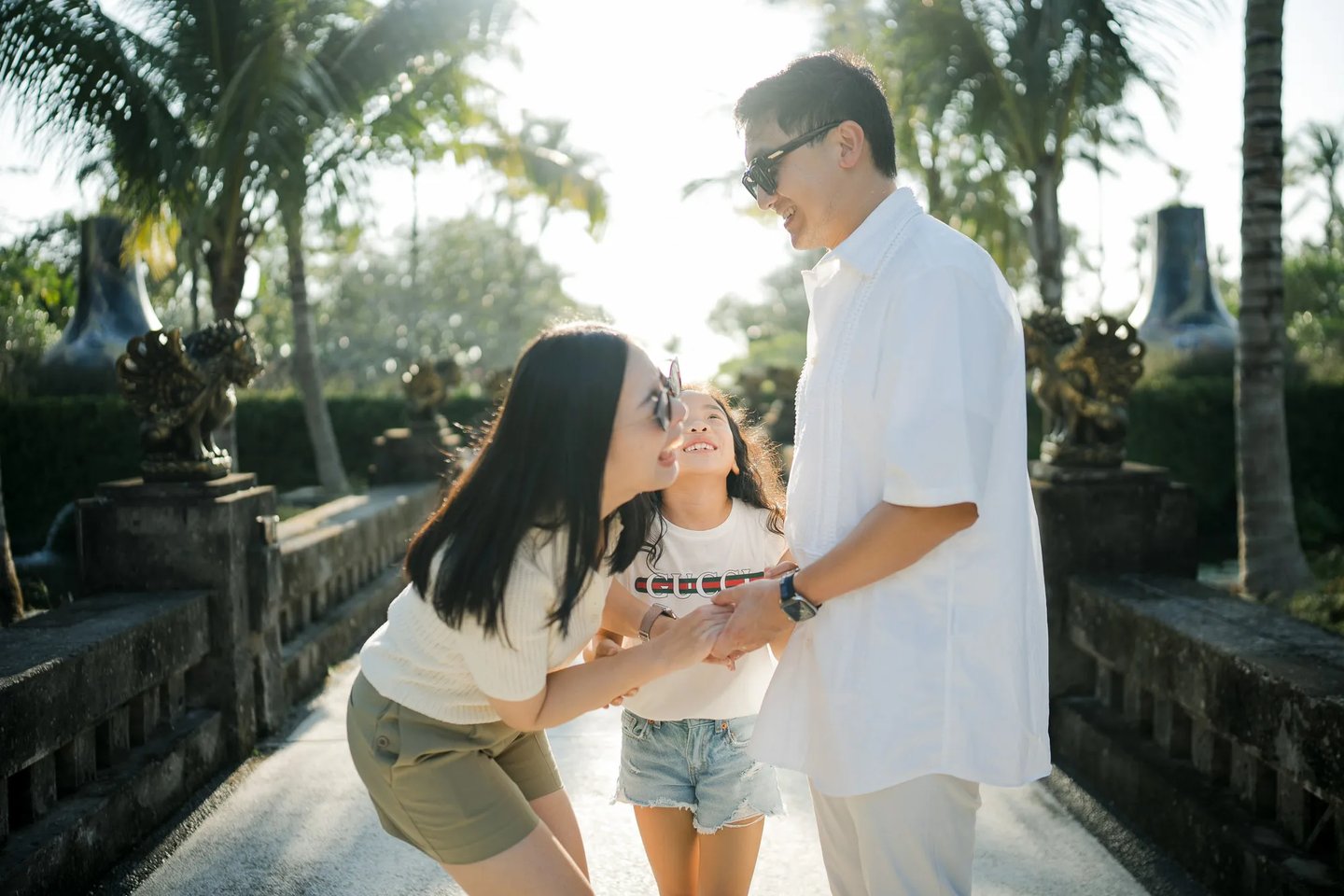 Parents and daughter sharing a playful interaction during a family photography session at InterContinental Bali Resort