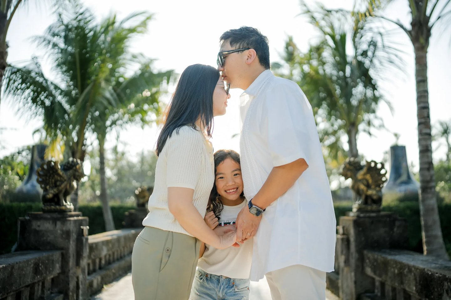 Family embracing together in the tropical gardens of InterContinental Bali Resort Bali