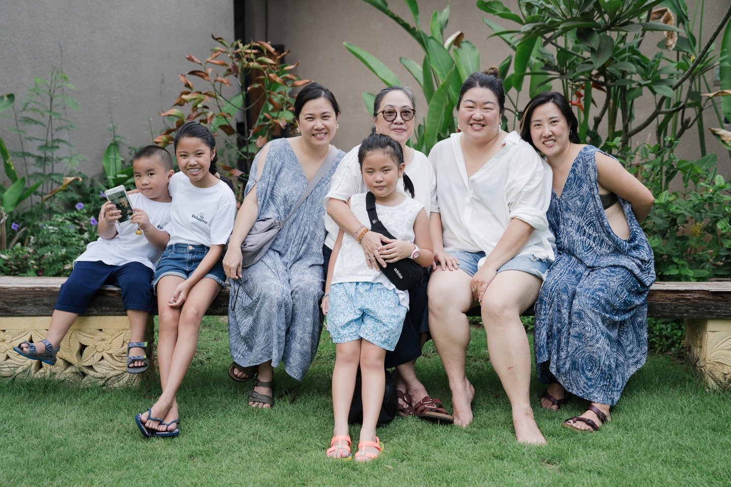 Extended family sitting together during photography session at Lumbini Villas Jimbaran Bali in relaxed garden setting