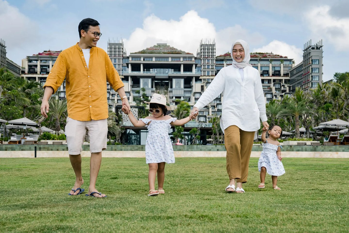 Muslim family walking together on the Ocean Lawn at The Apurva Kempinski Bali
