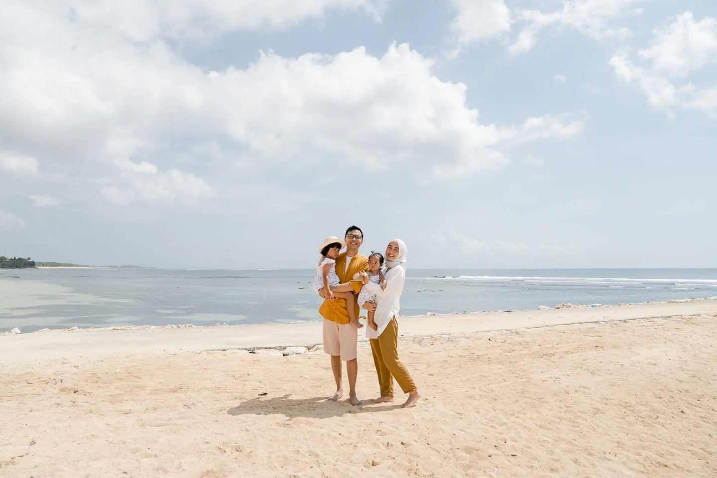 Family portrait by the shoreline at The Apurva Kempinski Bali beach