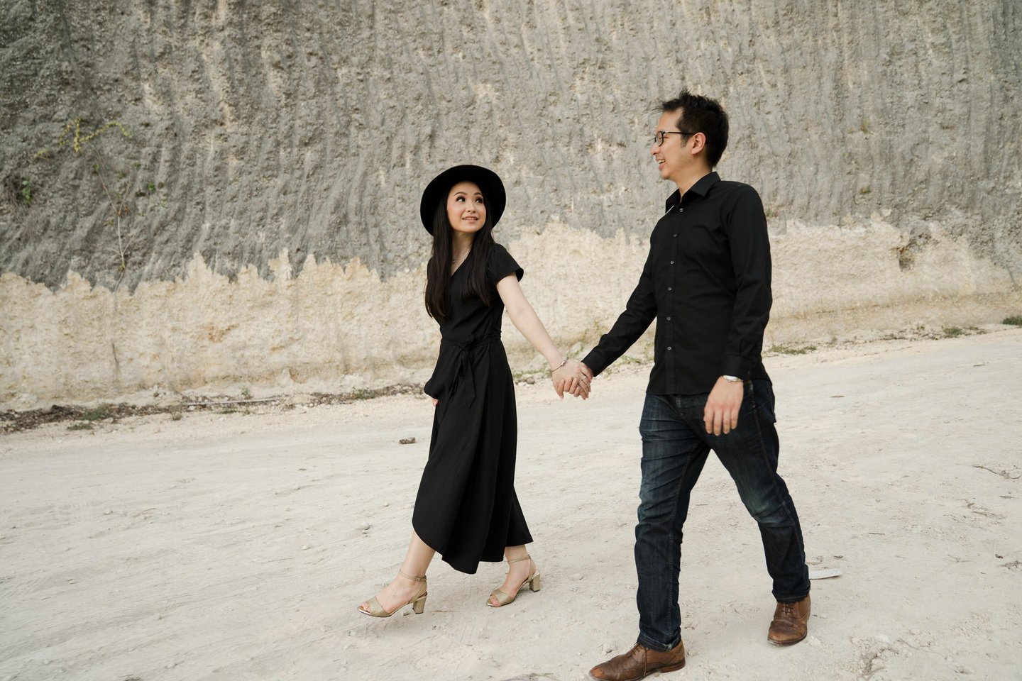 Romantic prewedding couple walking along Melasti Beach cliffs in Bali