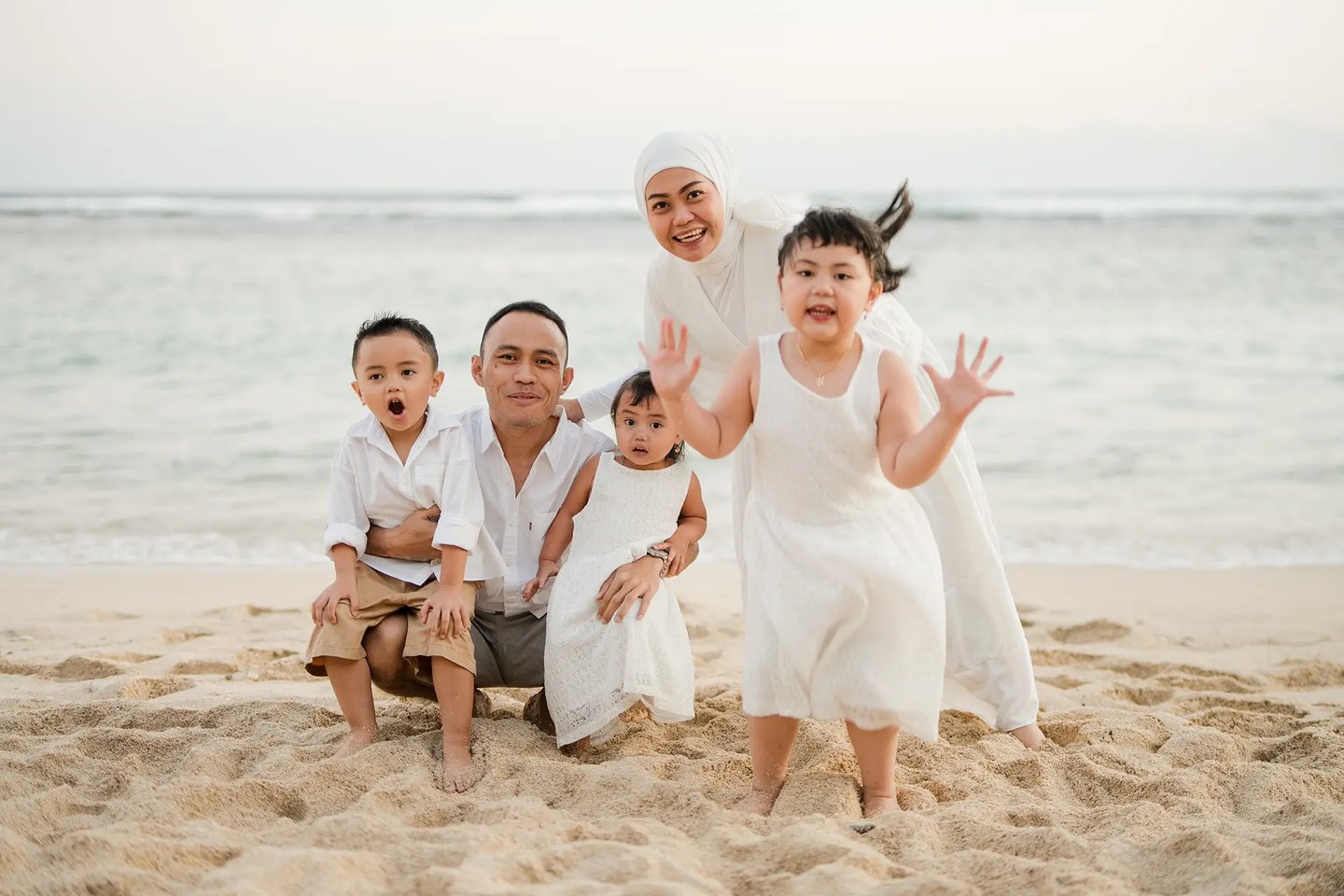 Fun and candid beach family portrait session of Ilham family at Melasti Beach Bali