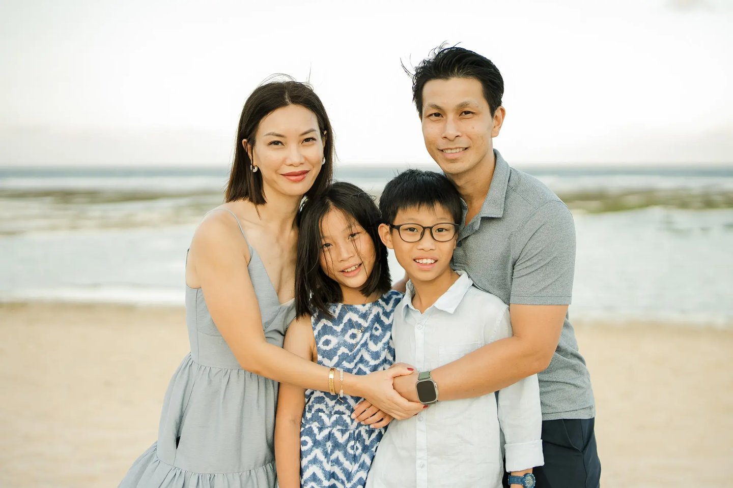 Family portrait by the ocean during a luxury family photography session at The Ritz-Carlton Bali.
