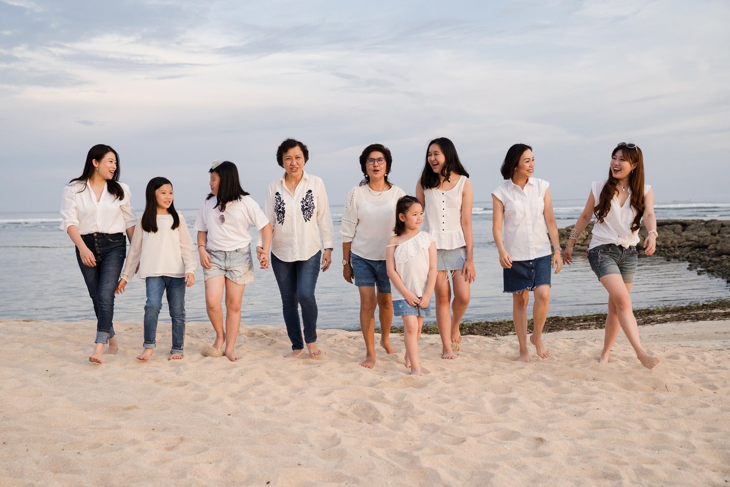 Large family gathering near the coastline during a family photography session at The Ritz-Carlton Bali
