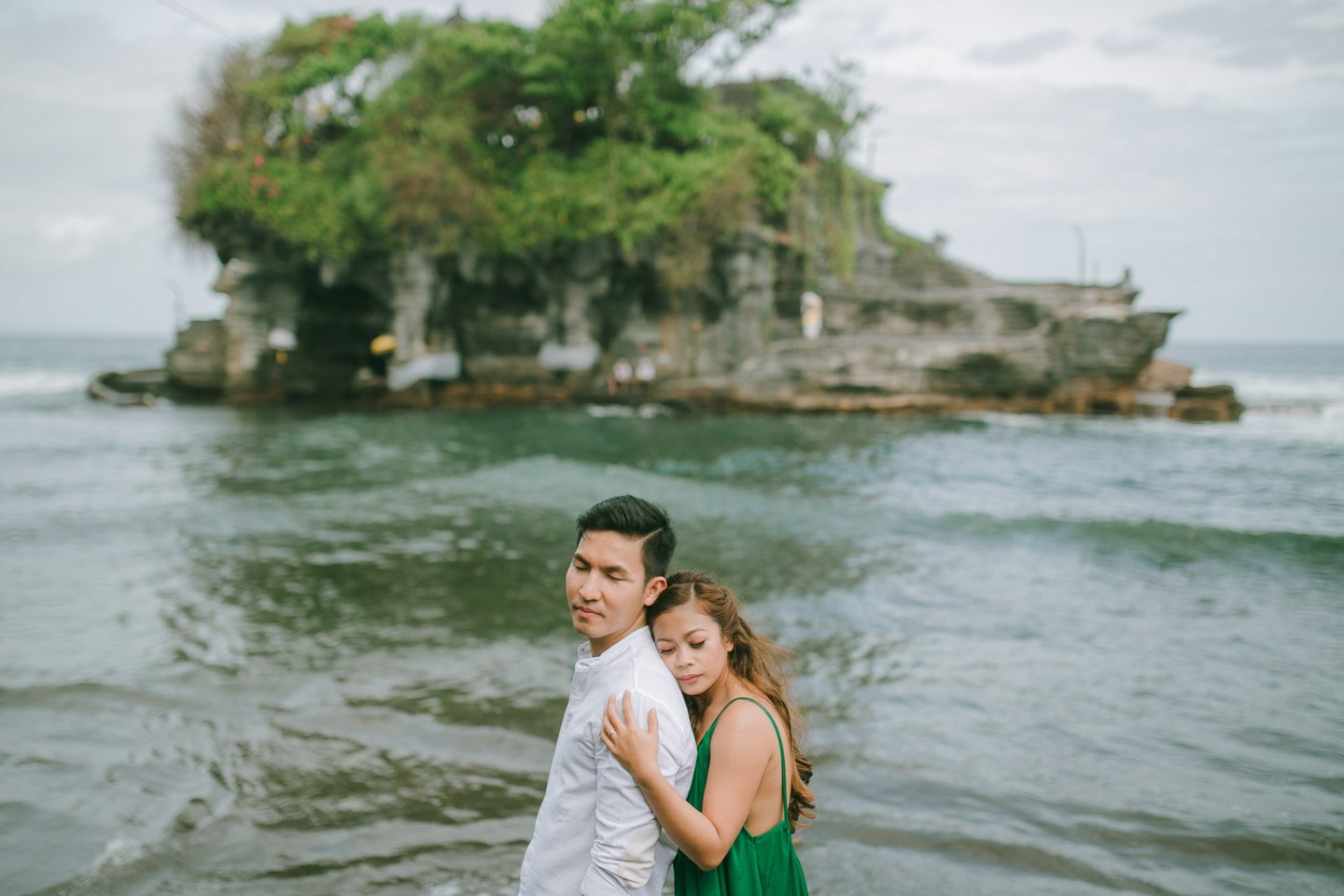 Couple portrait with Tanah Lot temple island in the background during a Bali intimate session.