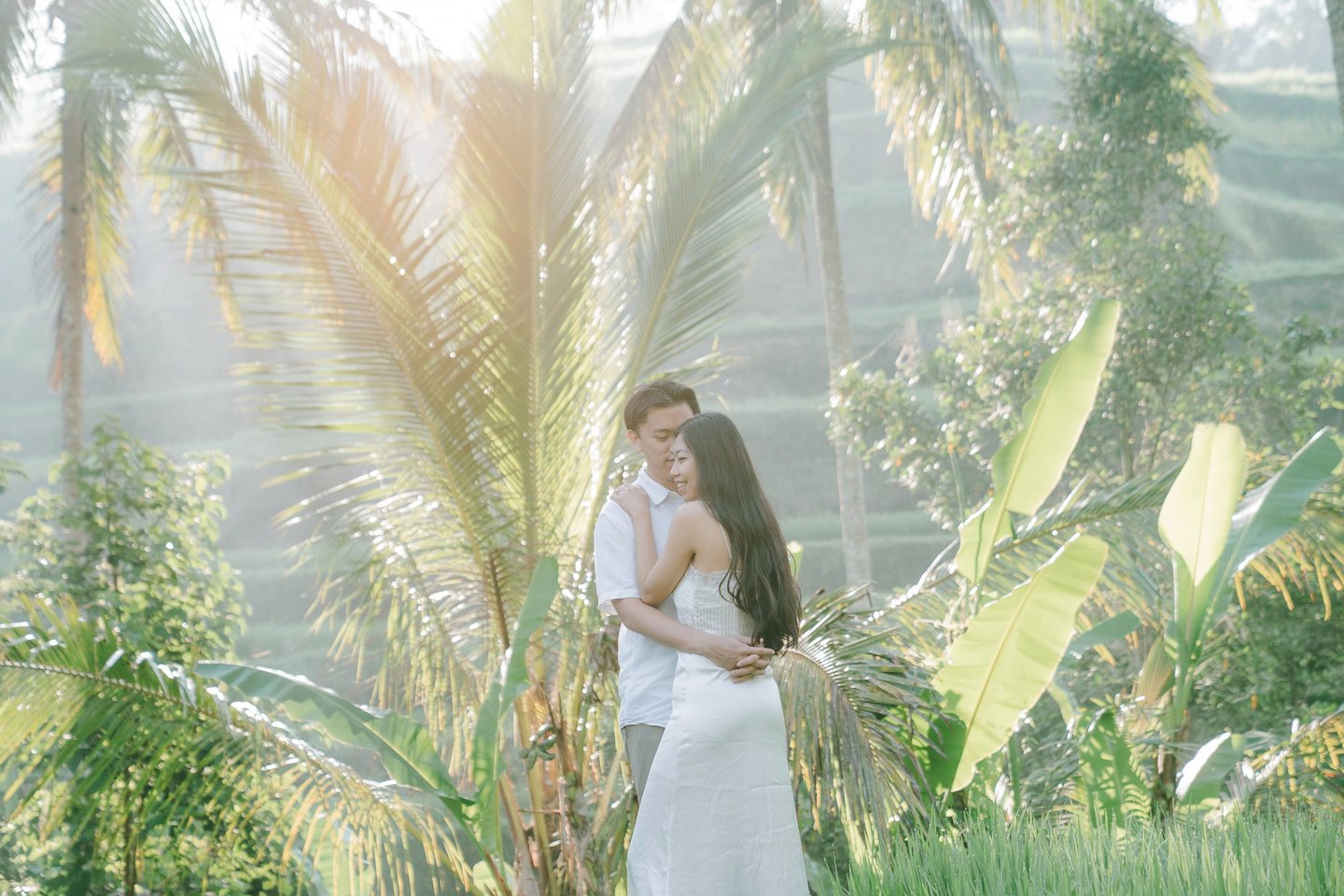Romantic couple under palm trees during a sunrise photography session at Tegalalang Ubud Bali.