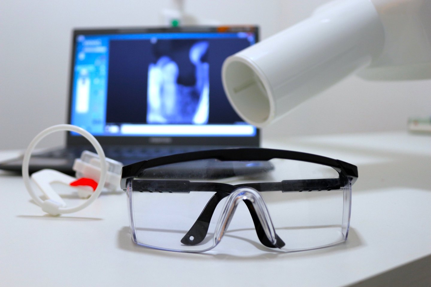 a laptop computer and a pair of X ray glasses on a desk
