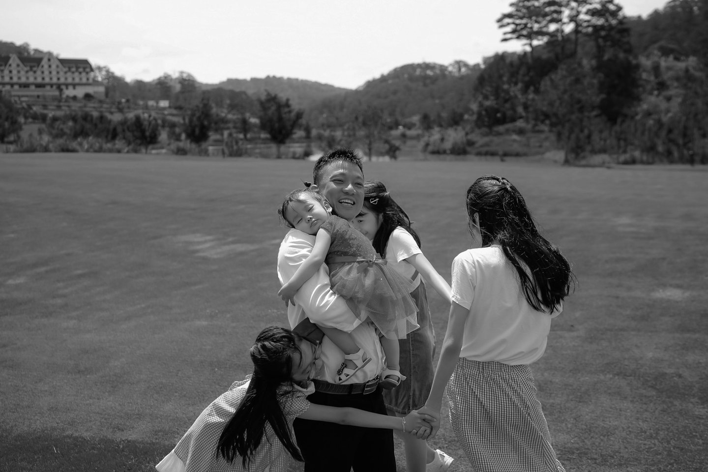 a family of four people standing around a woman holding a baby