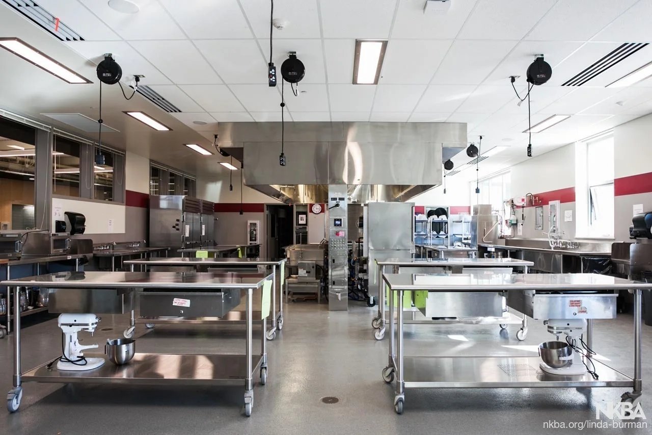 Large culinary teaching space with mobile stainless steel work tables and industrial prep stations from the About SSB team.