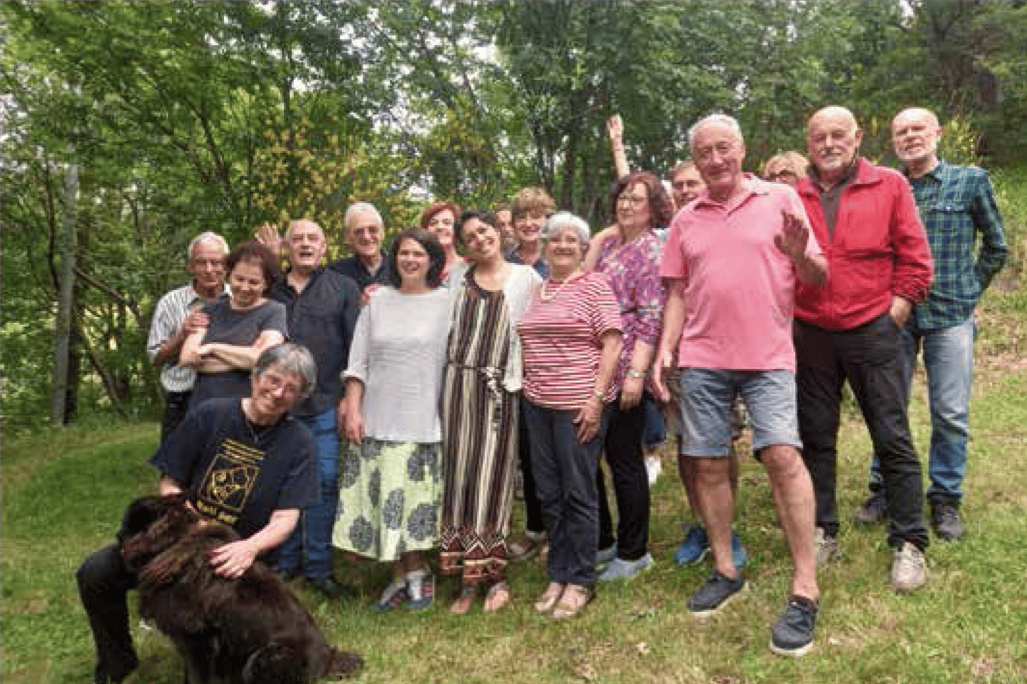 a group of people standing in a field with a dog