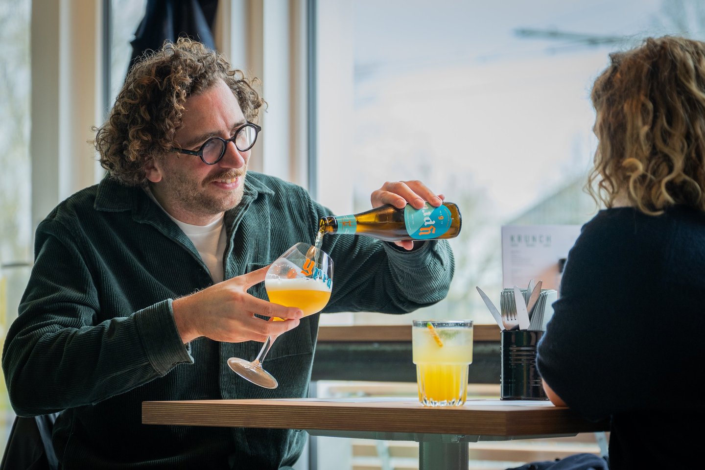 Gast schenkt een fris drankje in bij Krunch Gent