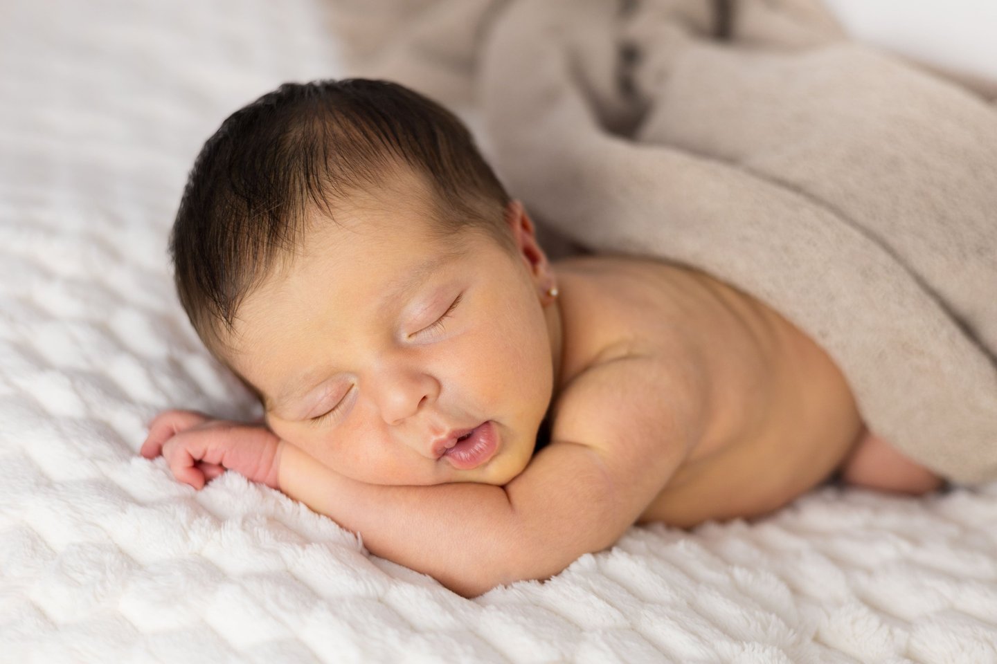 Sessió de fotos newborn a Girona amb una bebè recent nascuda dormint en estudi fotogràfic