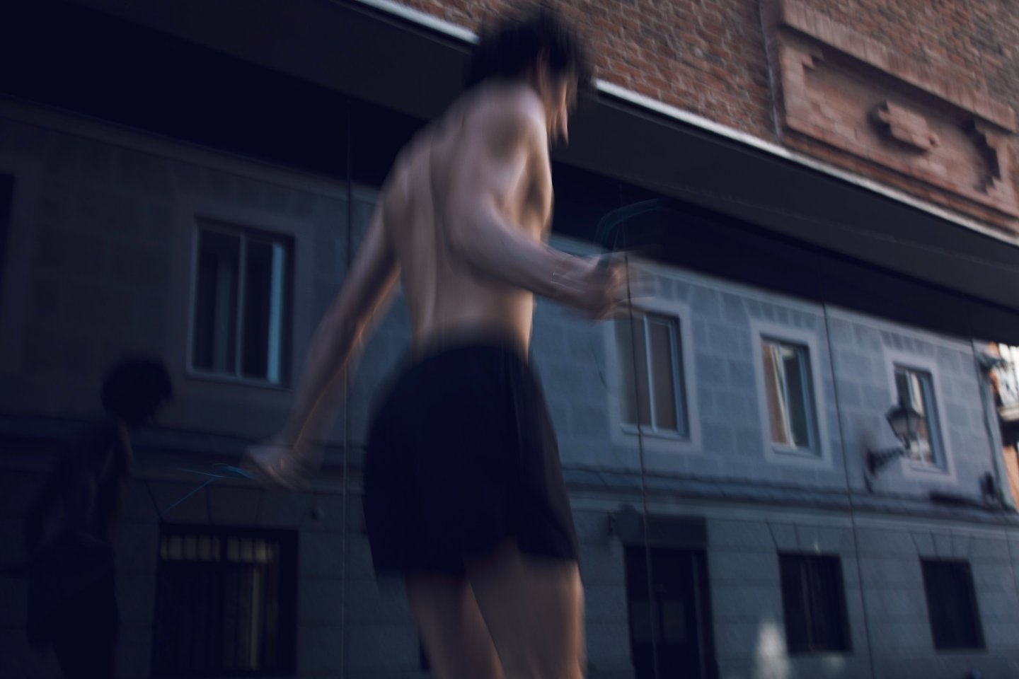 a man in a black shorts and a white shirt jumping the rope