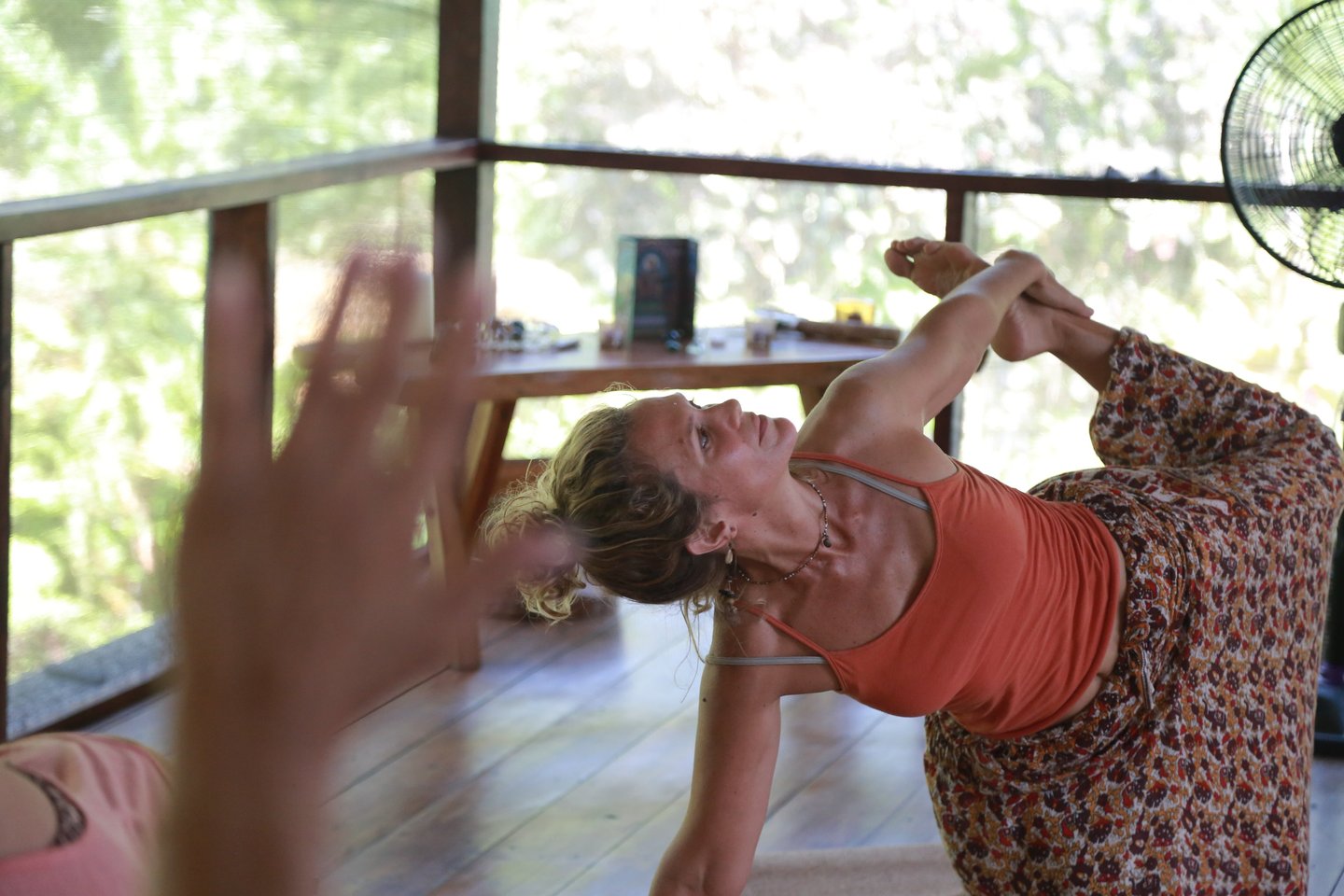 una mujer con un vestido de flores haciendo yoga
