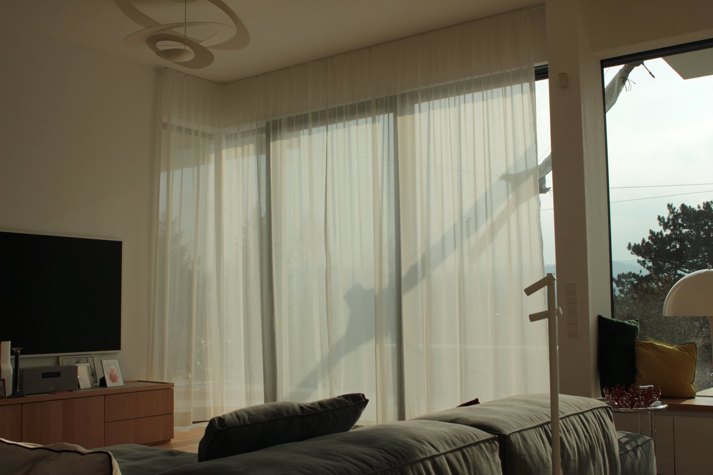 A big window hanged with wavy day curtains