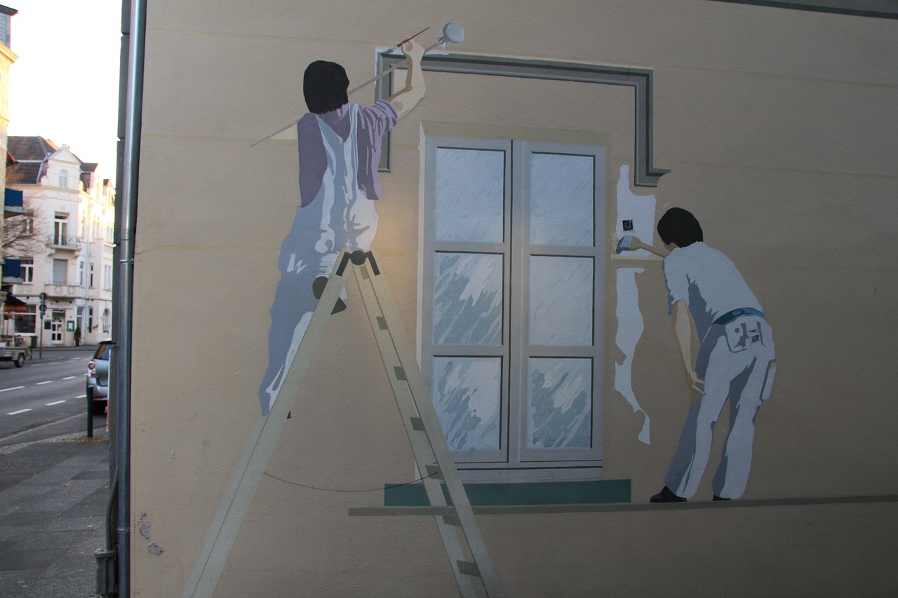 a man painting a mural of a man on a ladder