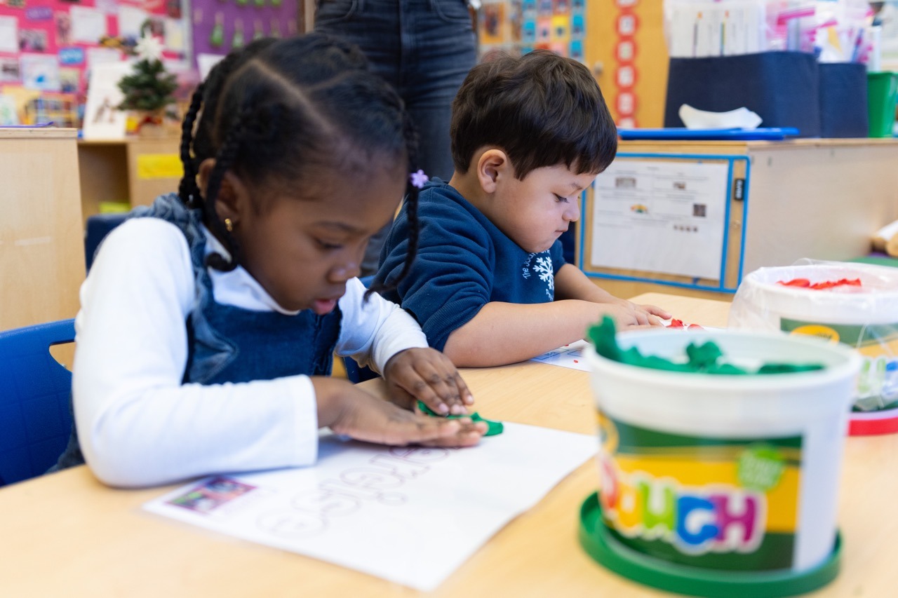 PreK students using playdough mats to develop fine motor skills.