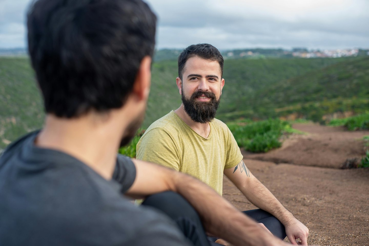 Two men having a conversation in the green countryside.