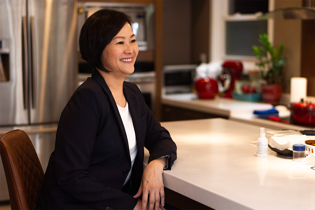 a woman sitting at a table looking to the right smiling