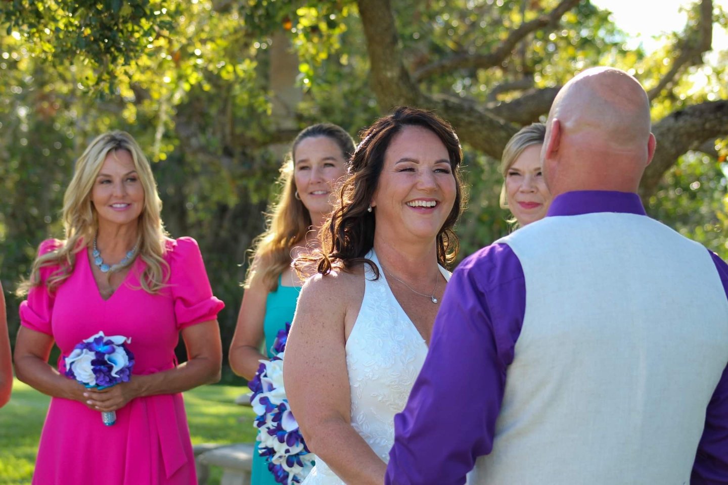 a bride and groomsmid are standing in front of a group of people