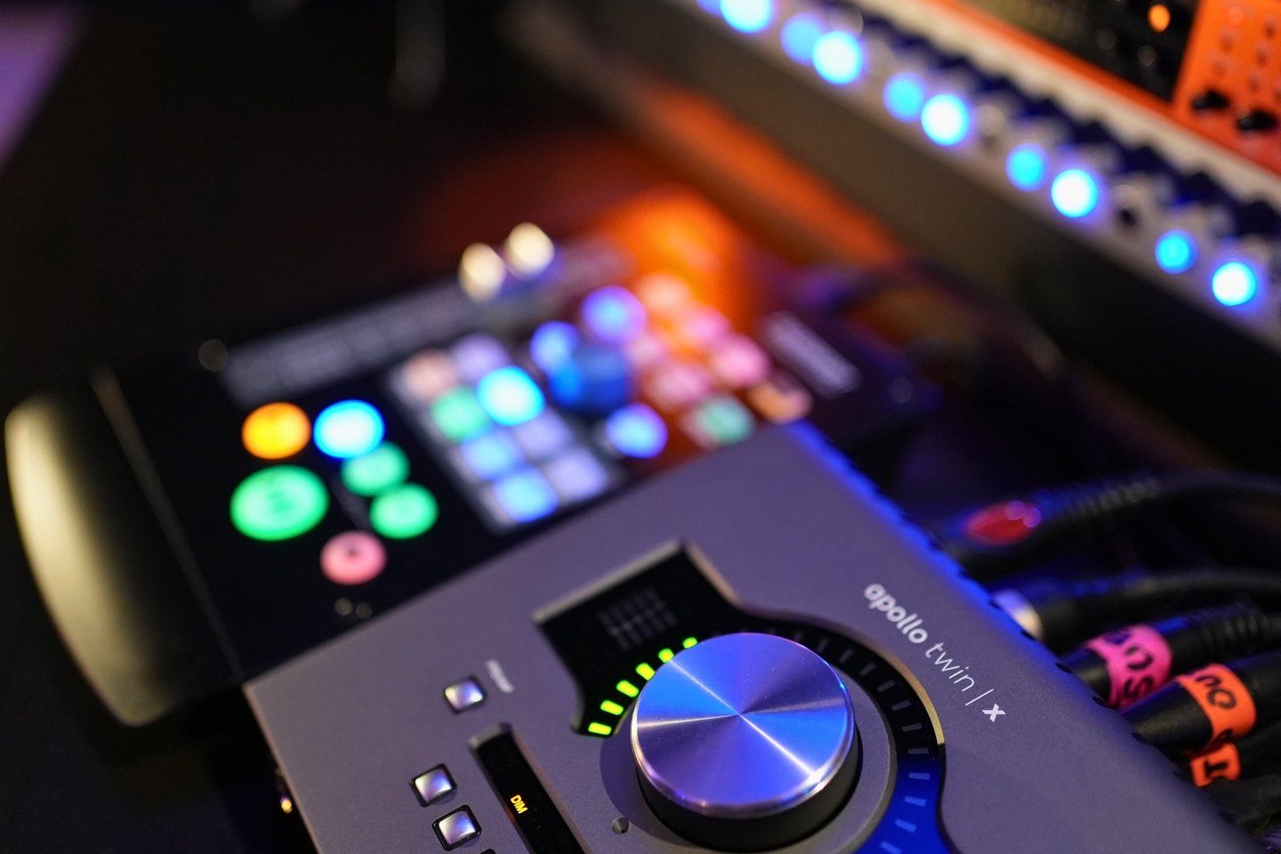 Close-up of a Universal Audio Apollo Twin audio interface on a mixing desk in a recording studio.