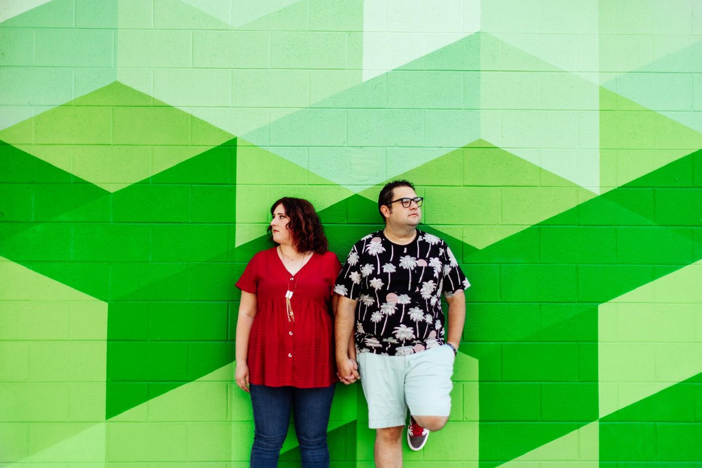Alamosa Consulting founders man and woman pose in front of a mural