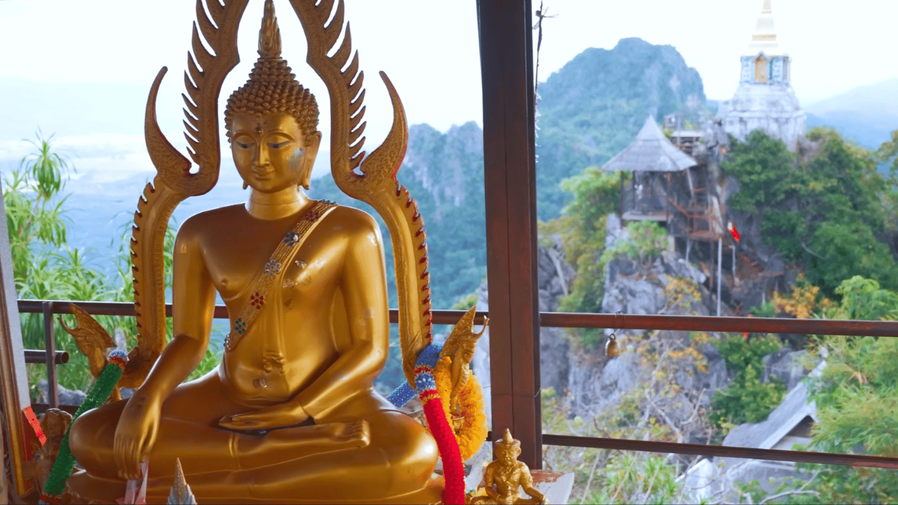 Temple statue in Lampang, Thailand, with background view of mountains.