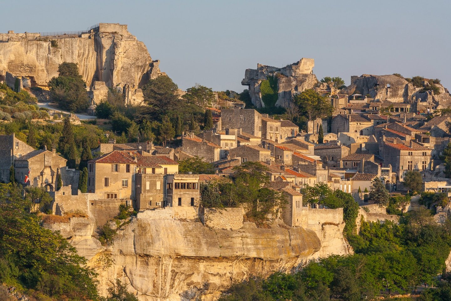 Panoramic view of the historic Les Baux-de-Provence village and its medieval fortress ruins on a rocky cliff.