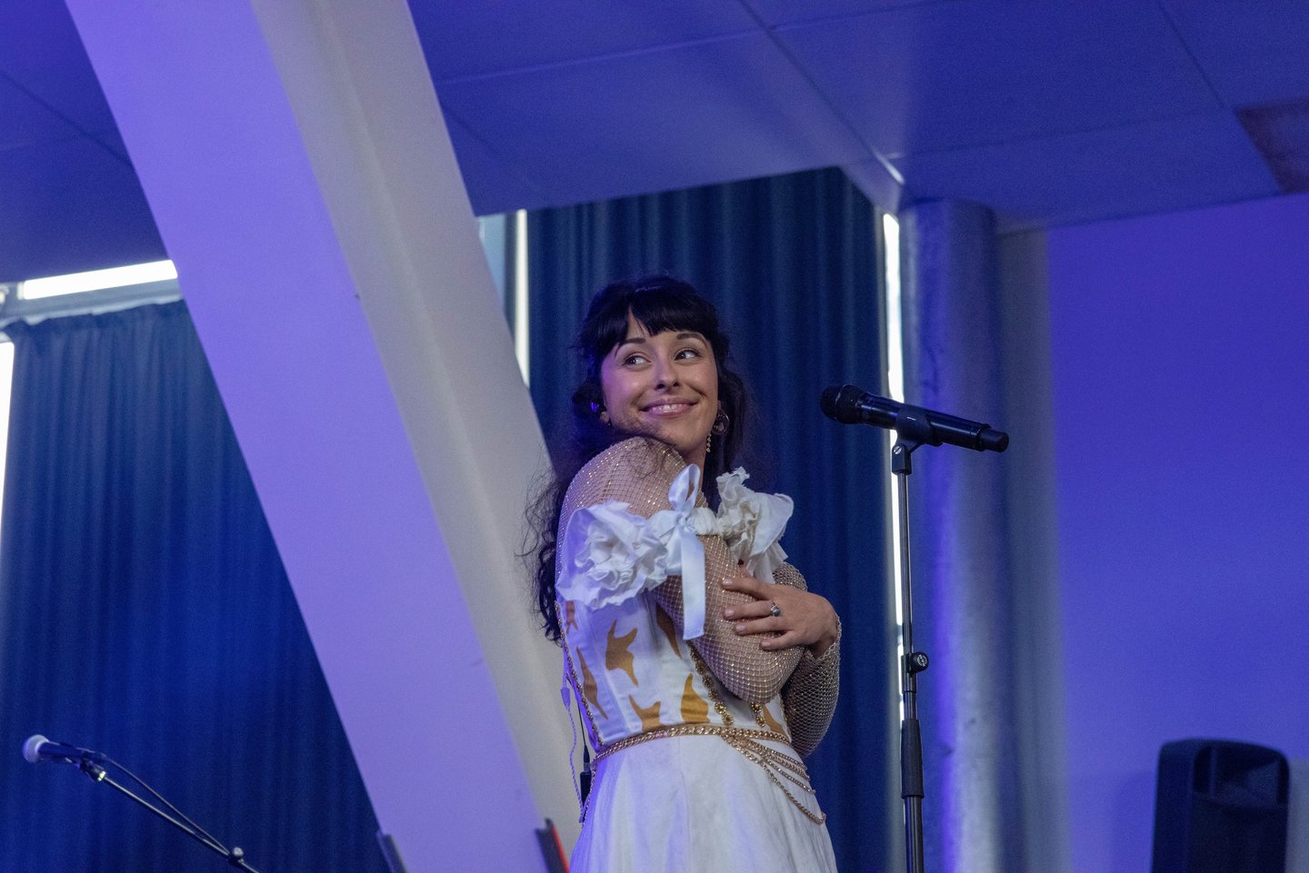 a woman in a white dress and a microphone