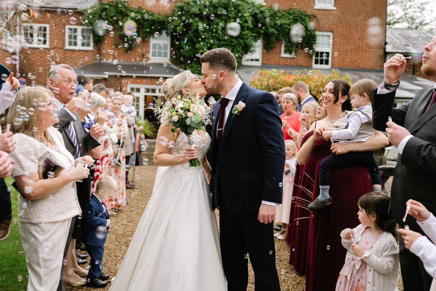 Couple kissing during bubble aisle shot at The Mill House Hotel