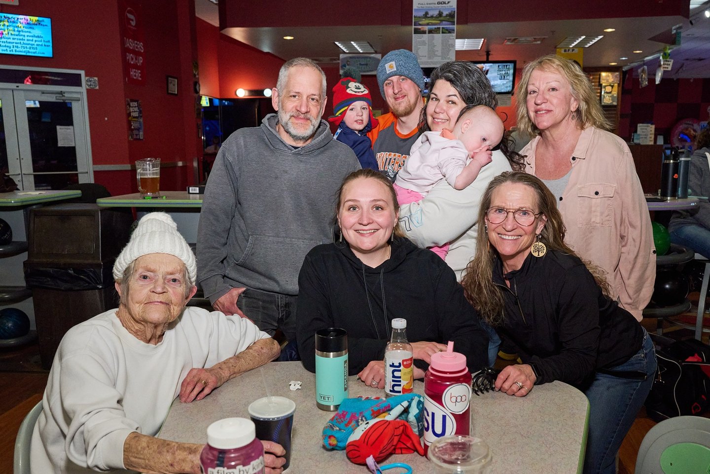 a group of people sitting around a table with a baby