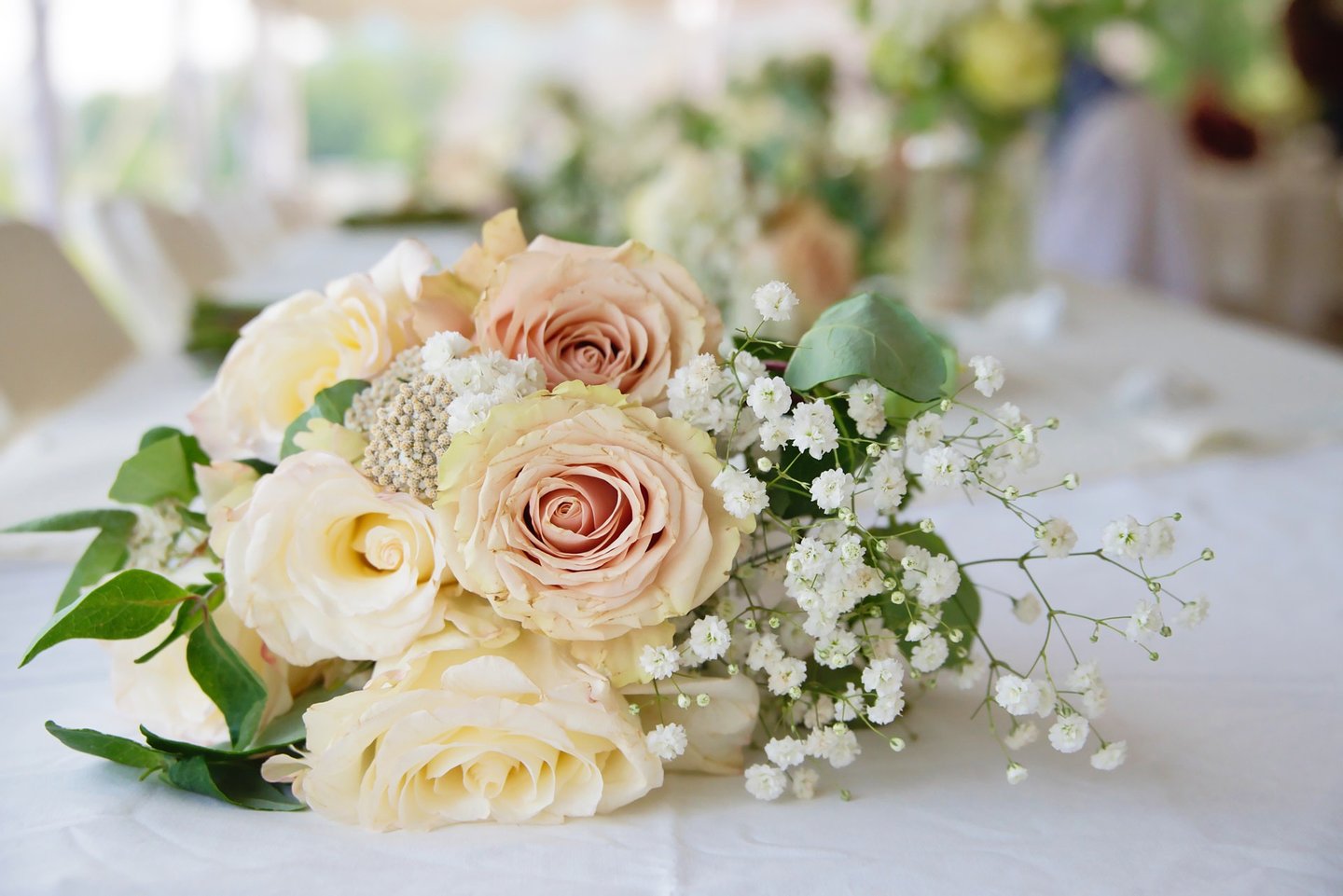 a bouquet of flowers on a table in a wedding reception