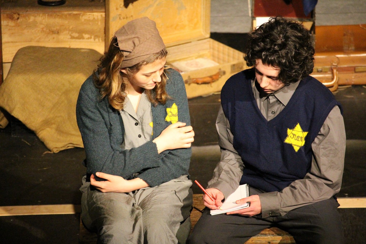 a man and woman sitting on a bench in a theatre
