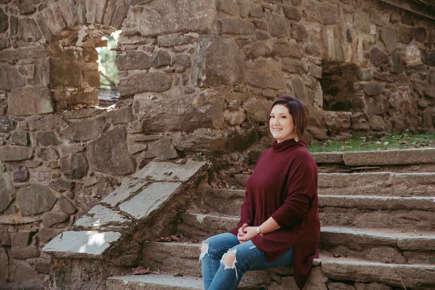 Photo of author Courtney J. Hall sitting on stone steps