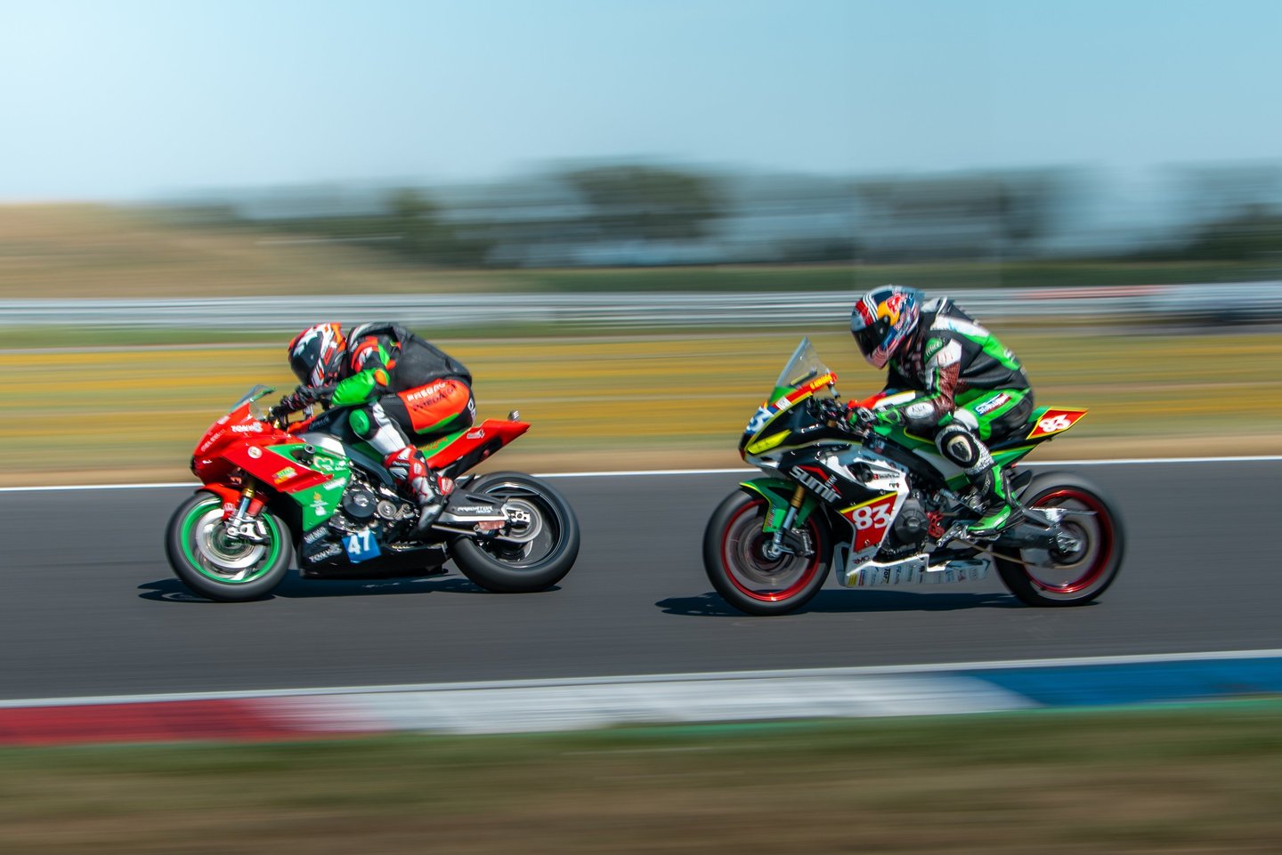 two people riding motorcycles on a track