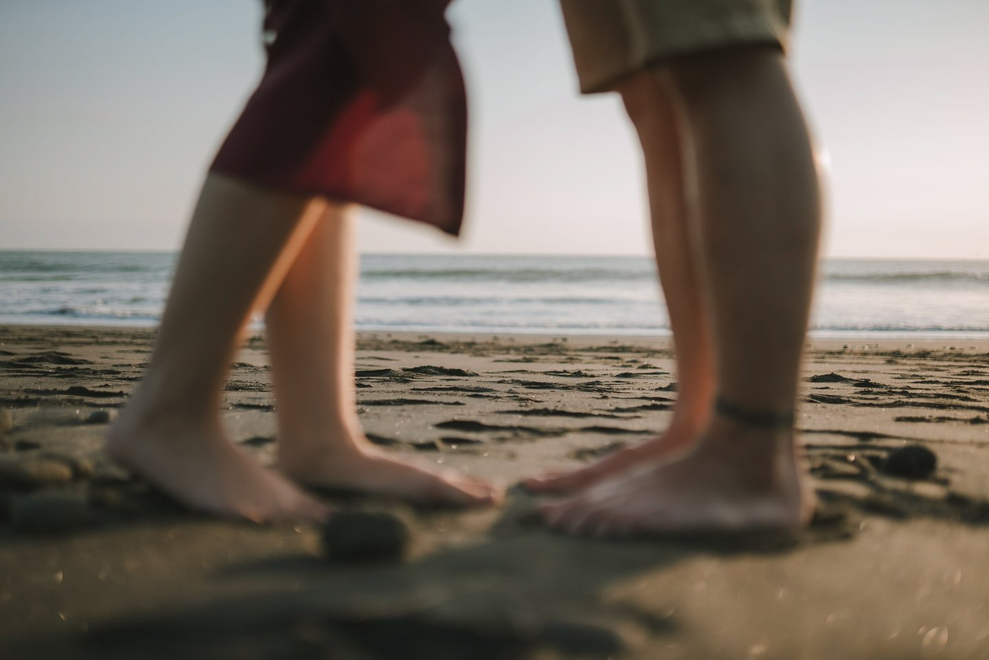 Close up of couple feet standing on sand during sunset session at Pantai Nyanyi Bali.