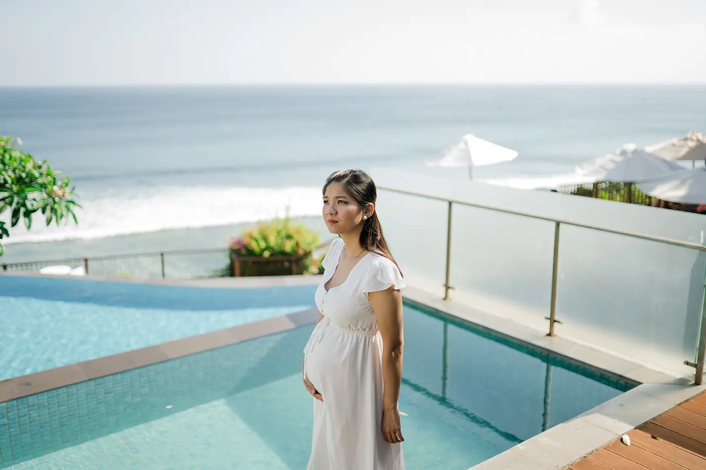 Parents sharing a quiet moment by the pool during a family session at Anantara Uluwatu.
