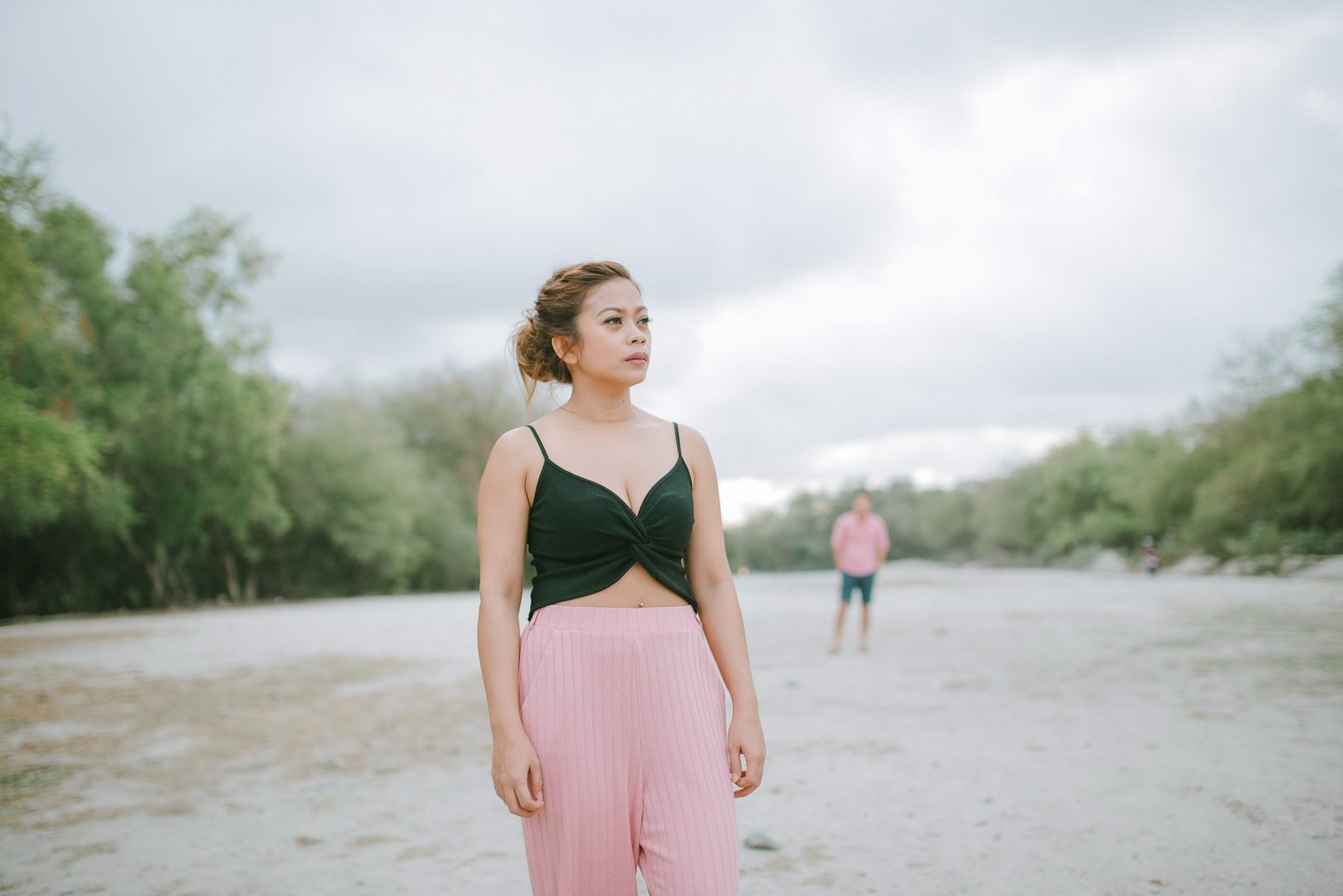 Woman standing on open beach during intimate couple photography session in Serangan Benoa Bali.