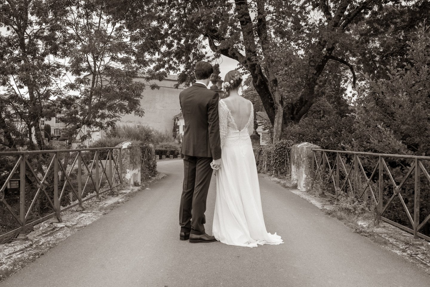 Deux jeunes mariés de dos sur un pont